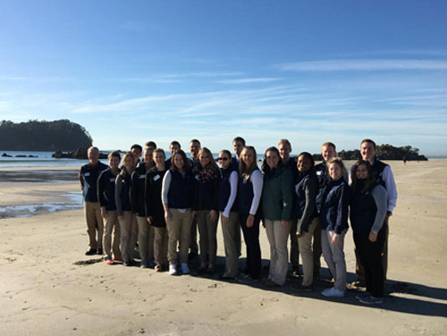 Study abroad students standing on a beach