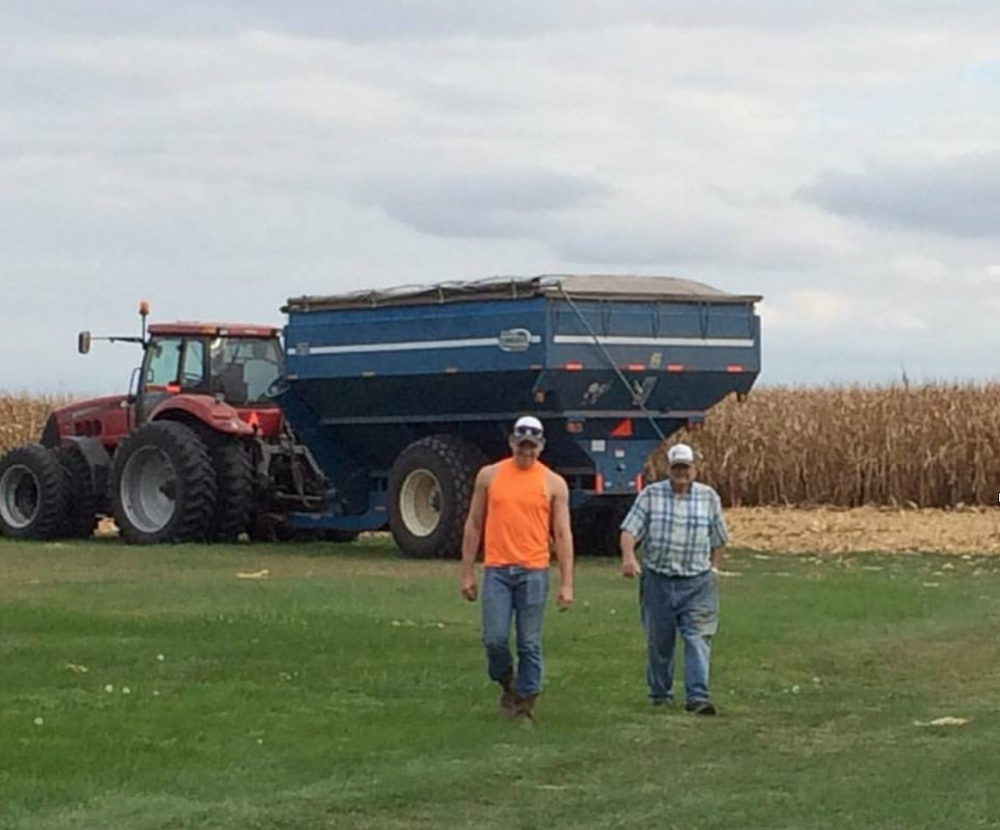 Mason and his 91-year-old grandpa walking by a combine