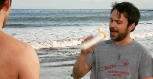 Gif of Charlie Day drinking sun tan lotion