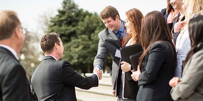 Student shaking hands with politician.