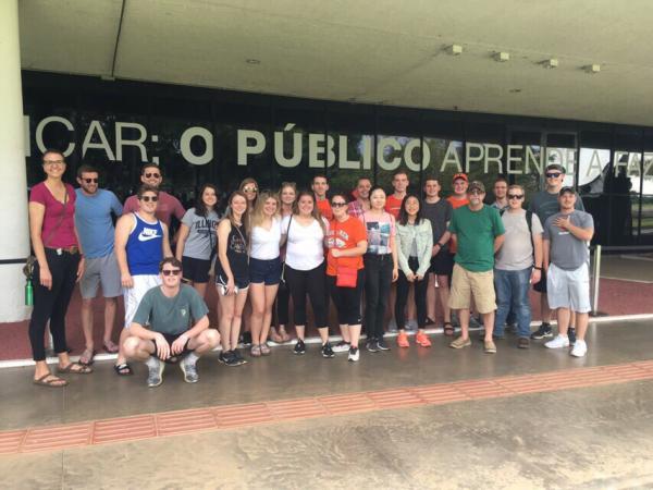 Study abroad students in front of a sign