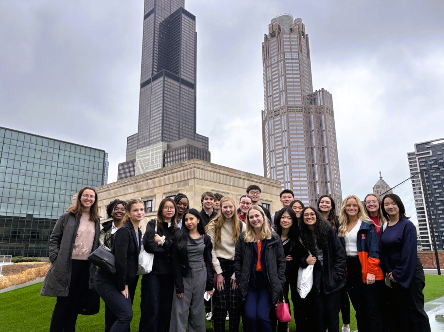 Students lined up for a group photo on a rooftop with the Chicago skyline in the background.