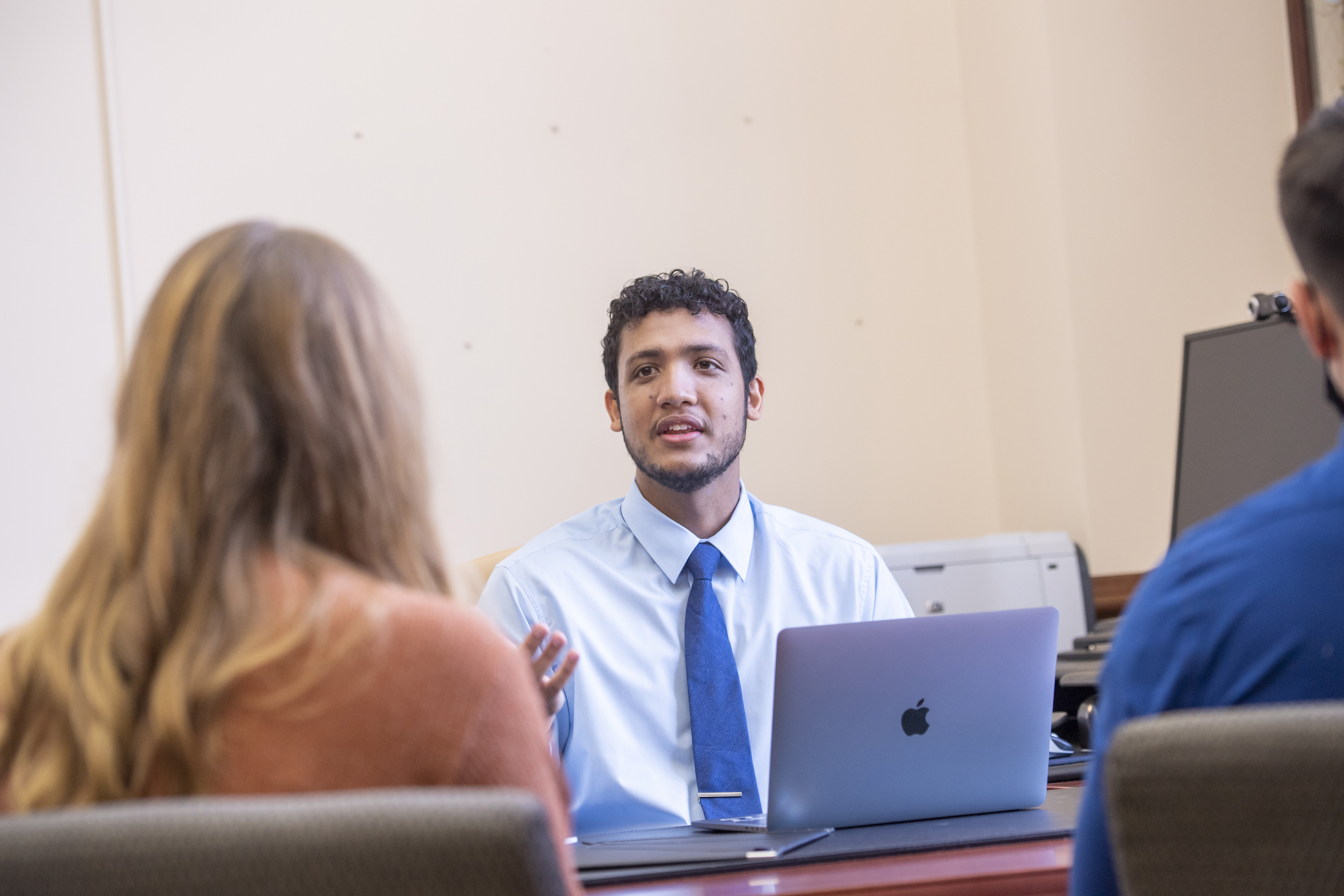 Student presenting at a computer to others