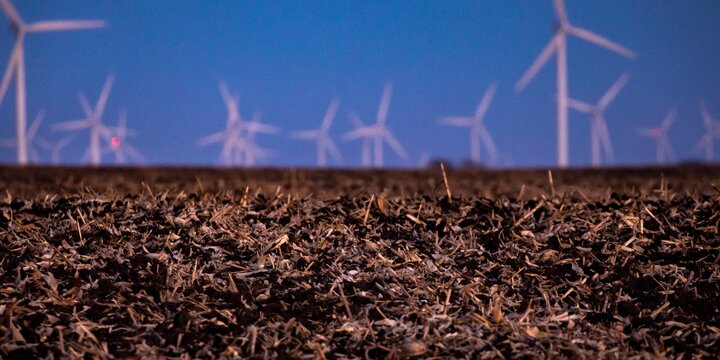harvested field with windmill in the back