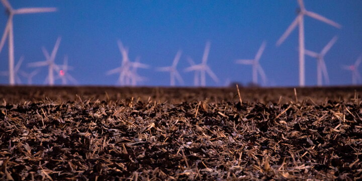 harvested field with windmill in the back