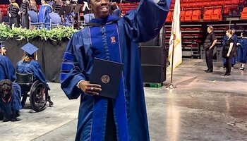 Graduate celebrating with diploma after crossing the stage