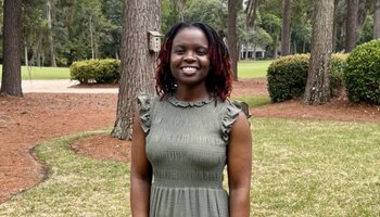 Alumna posing in her backyard