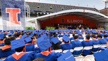 Graduates sitting and listening to speaker at university commencement