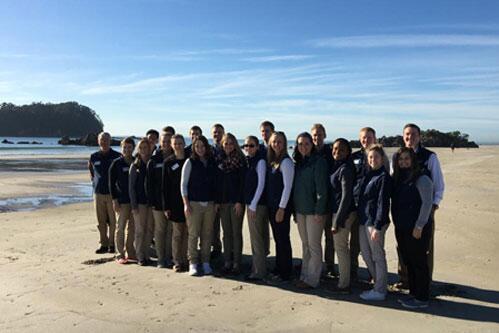 Study abroad students standing on a beach