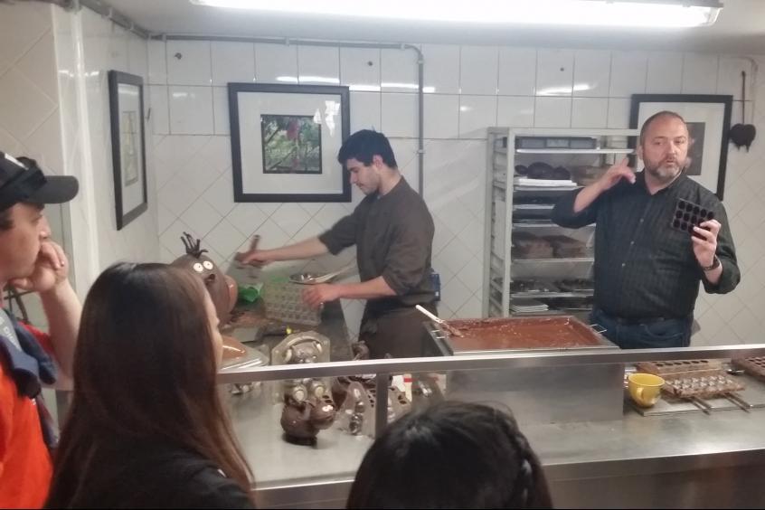 Students on a tour of a traditional Belgian chocolate factory