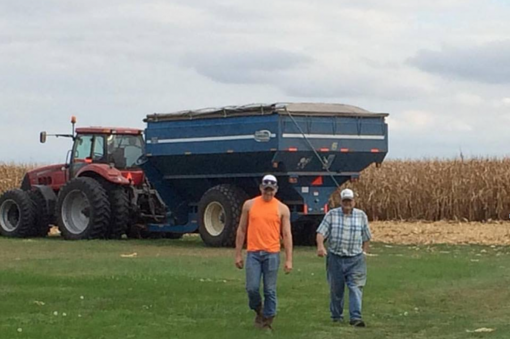 Mason and his 91-year-old grandpa walking by a combine